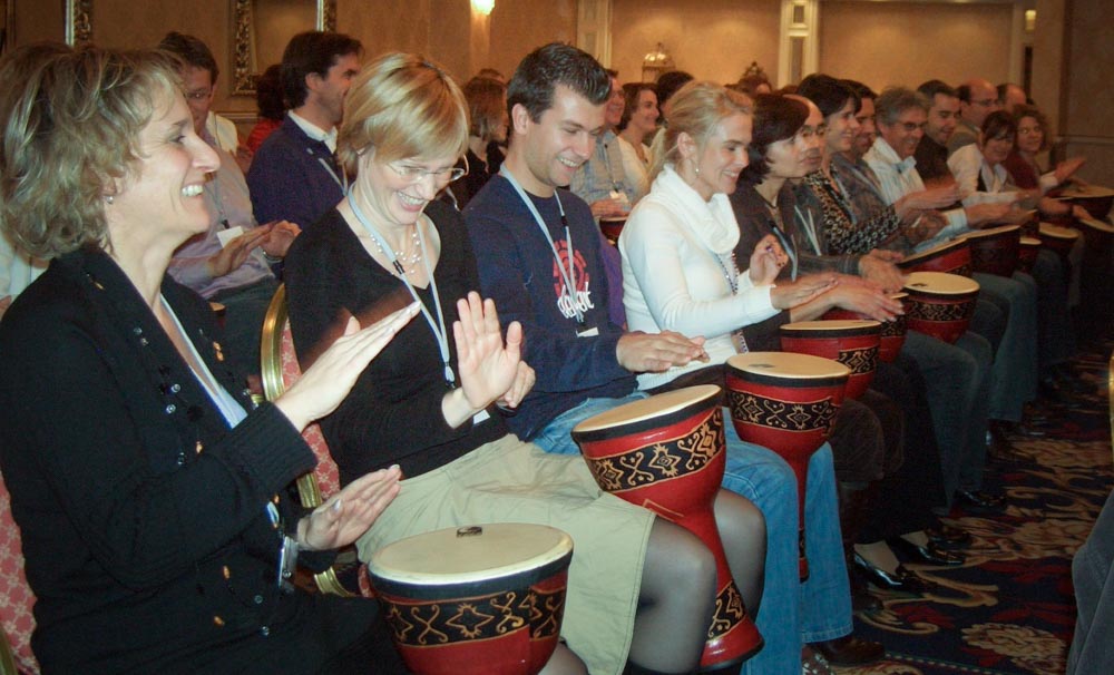 A room full of happy delegates playing drums - conference entertainment